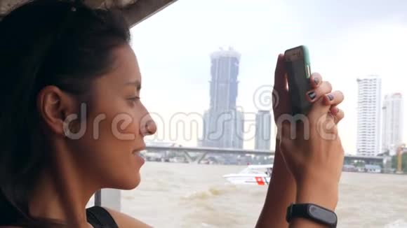 年轻的混合种族旅游女孩在泰国小船上巡游并使用手机拍照泰国曼谷4K视频的预览图