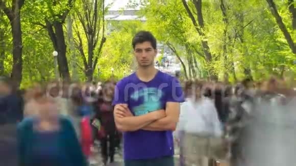 一个人站在人群中露头在背景绿树上时光流逝相机离开了视频的预览图