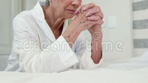 年长的女人在床上祈祷视频的预览图