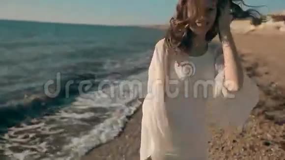 年轻漂亮的女孩走在海边和视频的预览图