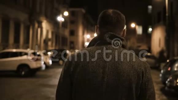 年轻时尚的男人独自走在荒芜的小巷里晚上思考着视频的预览图
