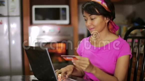 买信用卡的女人在厨房里网购视频的预览图