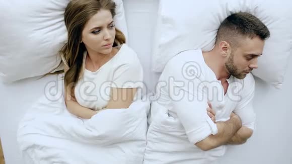 俯视图躺在床上的年轻夫妇吵架后有问题在家里互相生气视频的预览图