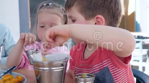 女孩子给男孩子做薯条酱男孩和女孩在餐馆吃一顿开胃的晚餐视频的预览图