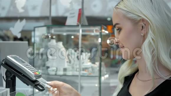 顾客在购物中心用信用卡支付他们的订单信用卡读卡机并退回视频的预览图