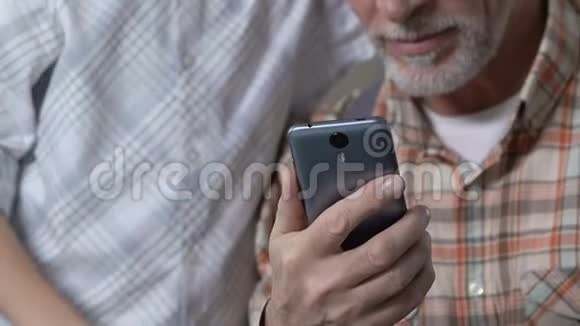 孙子教爷爷使用智能手机应用程序竖起大拇指视频的预览图