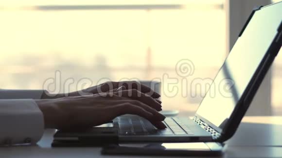特写女性手在笔记本电脑键盘上打字同时一位商界女性会在视频的预览图