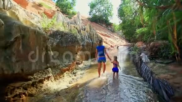 小女孩和妈妈一起沿着仙女溪散步视频的预览图
