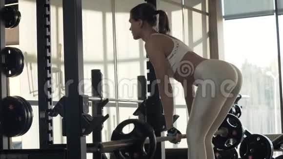 年轻女子在健身房的镜子前使用健身器材进行训练视频的预览图