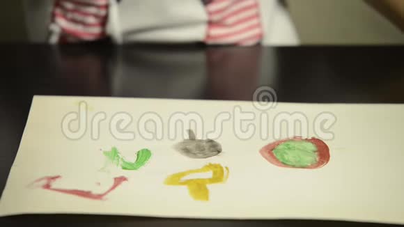 用水彩画在纸上用画笔孩子的手拍摄特写视频的预览图
