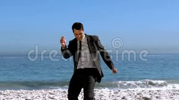 自由快乐的商人在海滩上跳舞视频的预览图