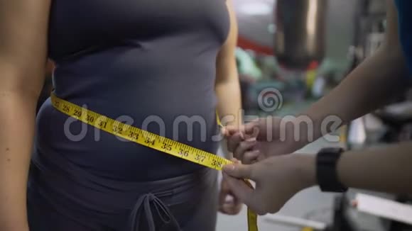 健身教练测量女性腹部健康饮食和锻炼结果控制视频的预览图