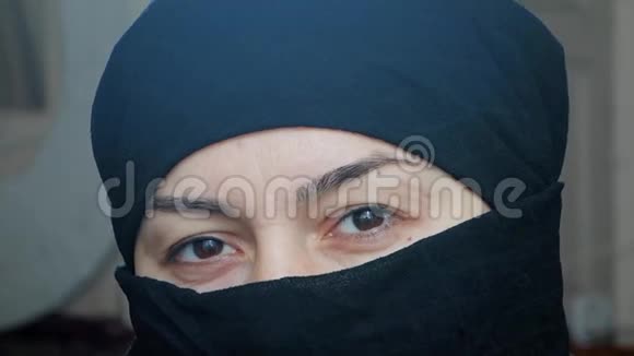 一个美丽的阿拉伯女孩的肖像一个穿着头巾的伊斯兰妇女看着镜头视频的预览图