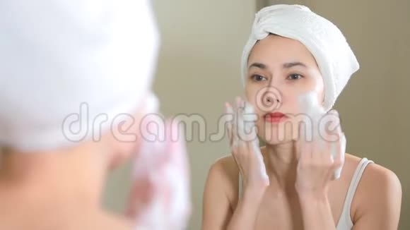 女人在浴室里用泡沫清洗她的脸视频的预览图