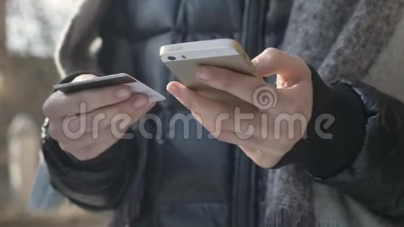女性手里拿着一部黑色的大智能手机和信用卡网上银行购物网上商店60fps视频的预览图