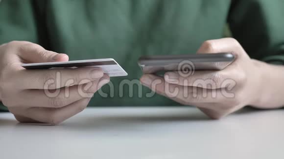 女性手里拿着一部黑色的大智能手机和信用卡网上银行购物60fps视频的预览图