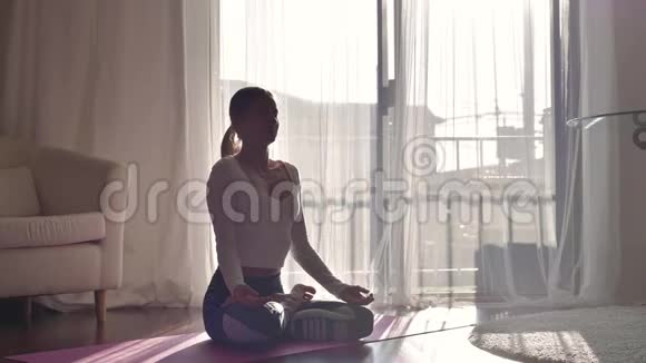 健康的女人在早晨用莲花姿势做瑜伽练习视频的预览图