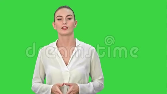 一位年轻的商业女性的肖像用一只手在绿色屏幕上呈现一些东西Chroma键视频的预览图
