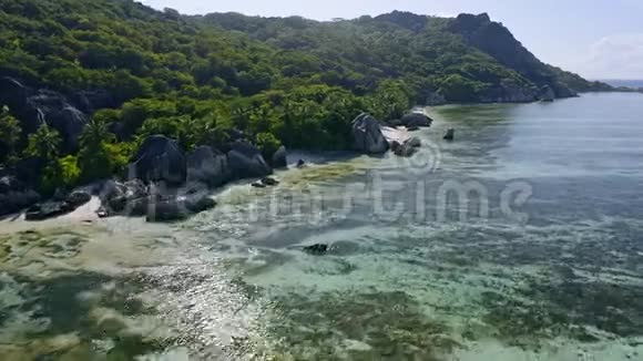 空中镜头沿着著名的Anse源d阿根廷热带海滩与独特的花岗岩巨石飞行阳光反射视频的预览图