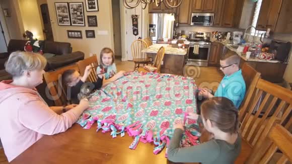 孩子们帮奶奶在餐桌上系被子视频的预览图