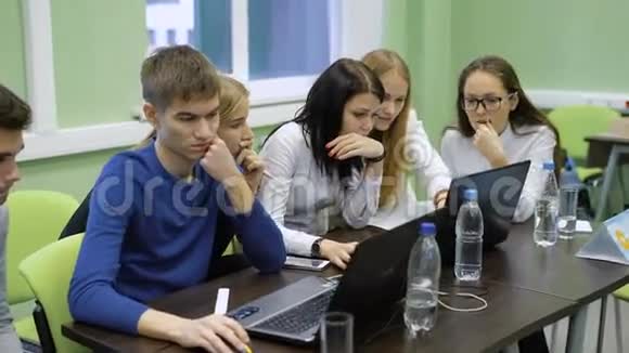 年轻的经理团队坐在桌旁手提电脑参与商业游戏的竞争视频的预览图
