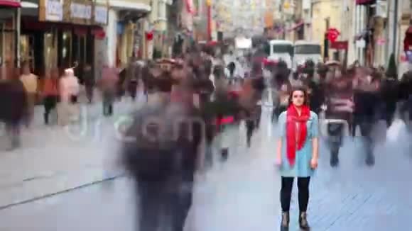 年轻女子摆姿势繁忙的街道人们走来走去高清视频的预览图