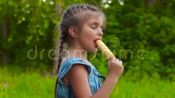 可爱的女孩在公园吃冰棍冰淇淋视频的预览图