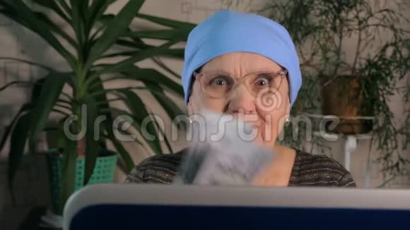 一位老妇人用笔记本电脑在网上赚钱视频的预览图