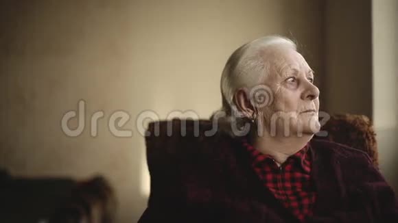 一个孤独的老人向窗外看的画像视频的预览图