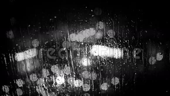 雨中透过窗户玻璃看到的城市灯光黑白镜头视频的预览图