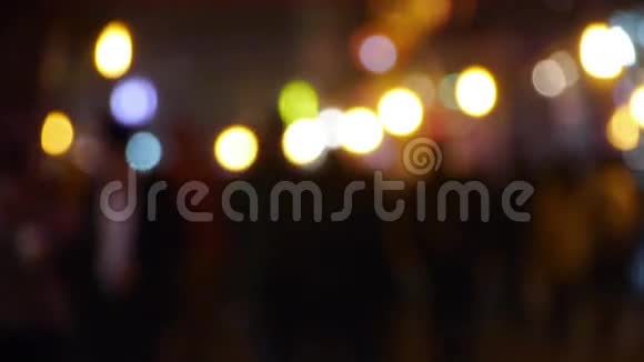 忙碌的人群轮廓和霓虹灯圈在商业街在晚上视频的预览图