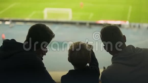 爸爸和两个儿子一起看足球赛周末快乐爸爸视频的预览图