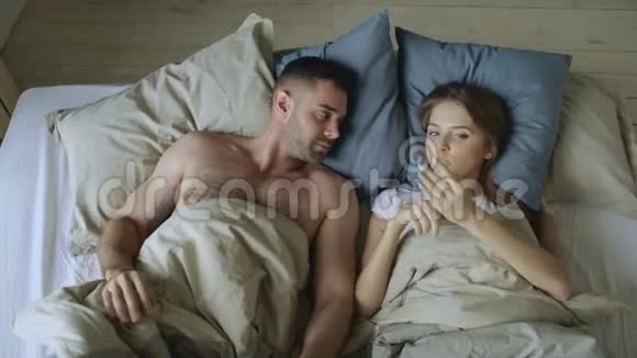 年轻漂亮的情侣在床上聊天玩得开心视频的预览图