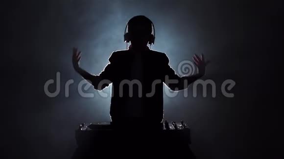 剪影男孩DJ跳跳跳舞和播放音乐慢动作视频的预览图
