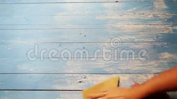 一个人用砂纸打磨木板以使其看起来更老的加速镜头视频的预览图