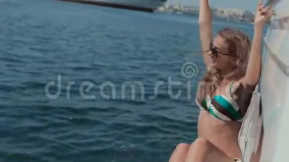 漂亮的女孩在海边的豪华游艇上开车视频的预览图