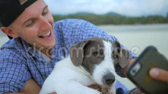年轻人在海滩上用狗做自拍泰国高清慢速运动视频的预览图
