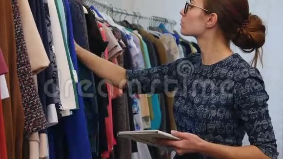 有吸引力的服装店老板的肖像女人手里拿着数字平板电脑在商店里工作视频的预览图