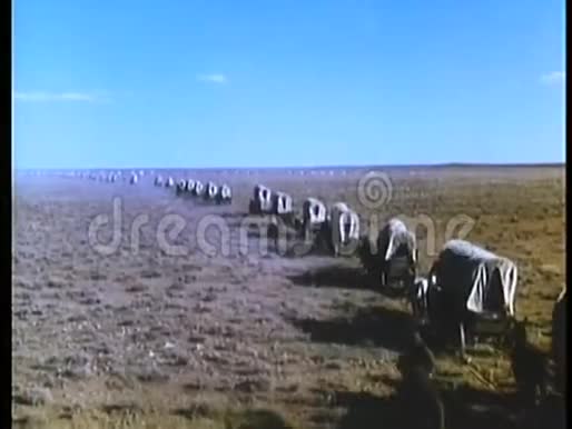 蒙太奇带盖的马车和移民穿越国境视频的预览图