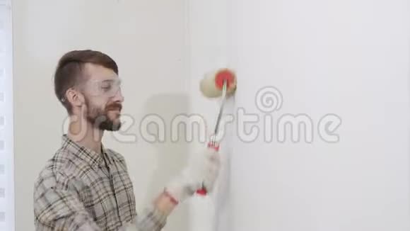 画家在工作用滚筒画墙画家的房子概念视频的预览图