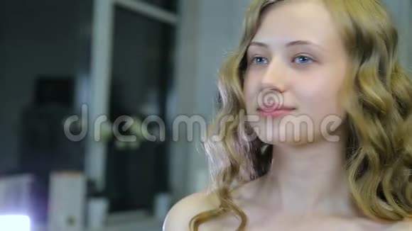 美丽的年轻女孩一头长长的卷发蓝眼睛在化妆前照自己视频的预览图