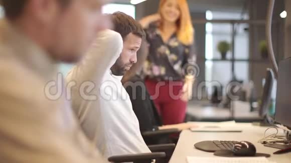 劳累过度的年轻商人在办公室的电脑上辛勤工作视频的预览图