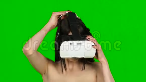 女士使用虚拟现实耳机VR面具特写绿色屏幕视频的预览图