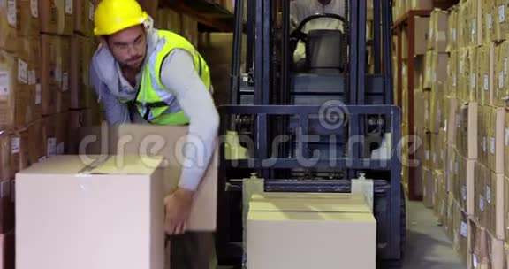 仓库工人包装箱放在叉车上视频的预览图