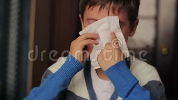 生病的男孩把鼻子吹进餐巾里视频的预览图