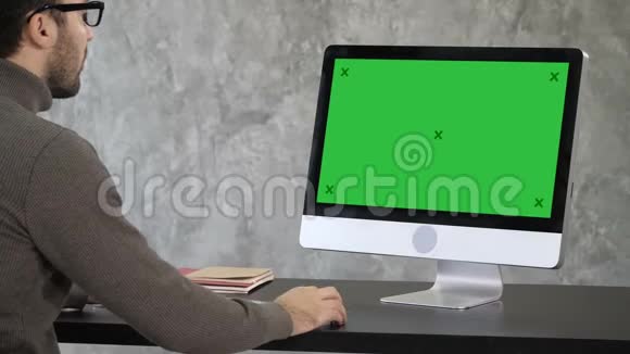 优雅的商人在他的电脑上分析办公室的数据回到监视器绿色屏幕模拟显示视频的预览图