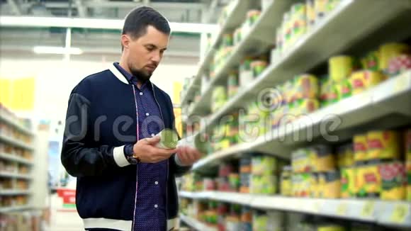 在超市里选罐头蔬菜的男人视频的预览图