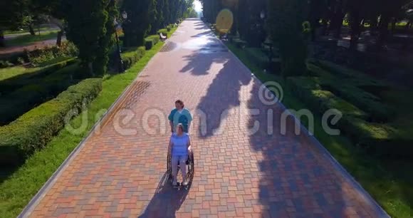 照顾者与残疾长者轮椅行走的空中镜头视频的预览图