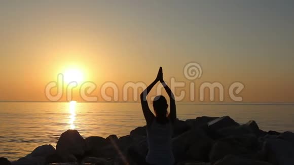 早上冥想女人在海边练习瑜伽在佳能EOS5D马克IV上拍摄慢动作视频的预览图