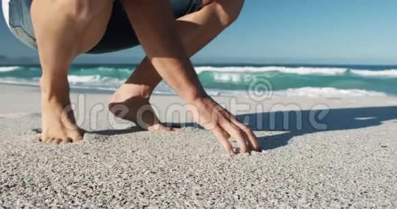 蹲在海滩上的人视频的预览图